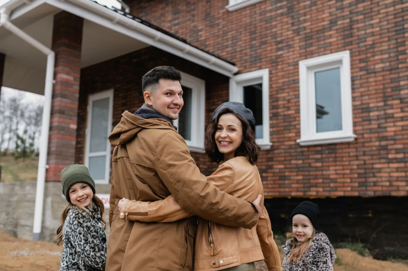 Una familia junta frente a su casa